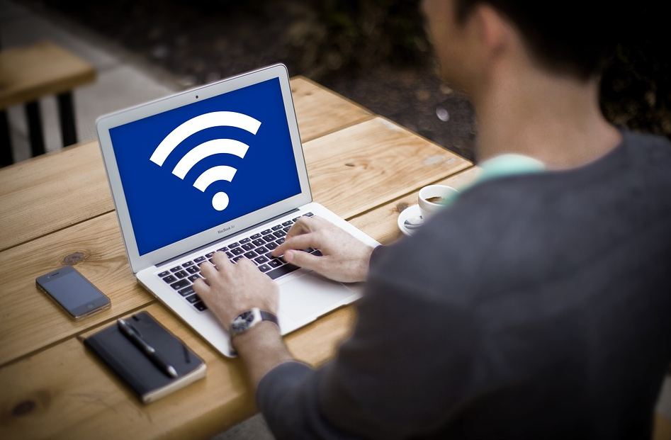 man using laptop showing wifi symbol