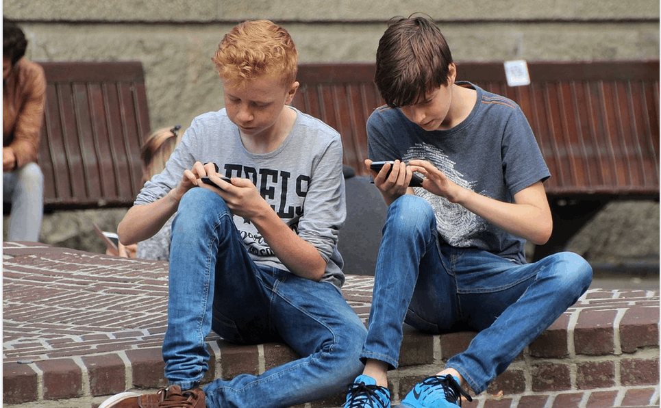 boys enjoying gaming on mobile phones